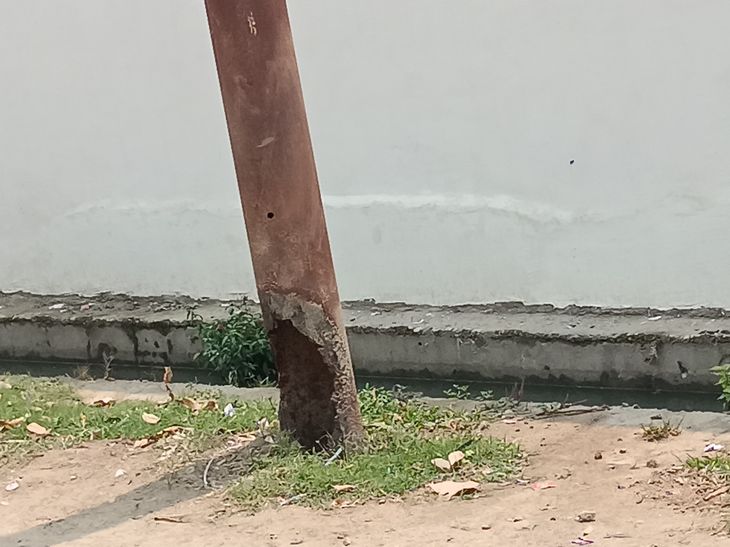 A dilapidated electricity pole in front of the school