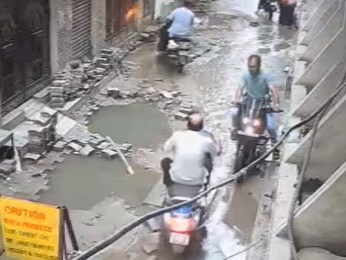 Scooty rider fell into the pit along with the scooter..VIDEO