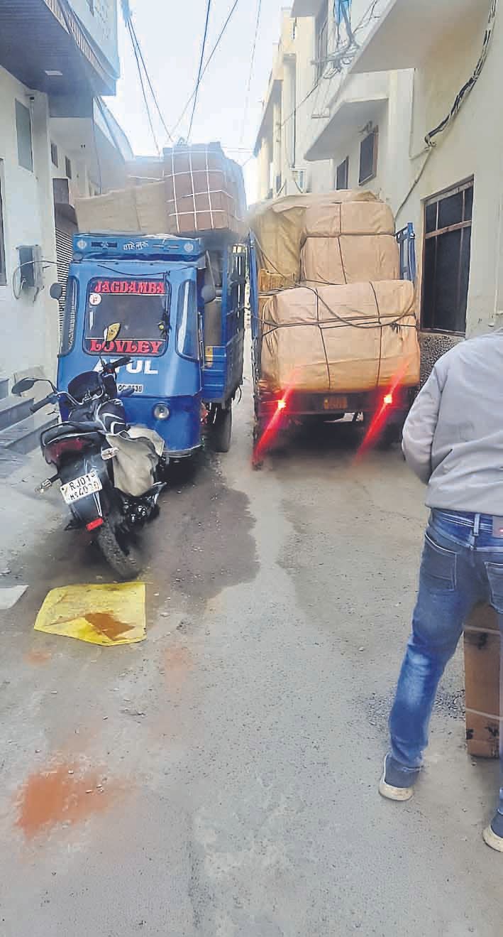 Overloaded mini-tempos and e-rickshaws carrying luggage ply the narrow ...