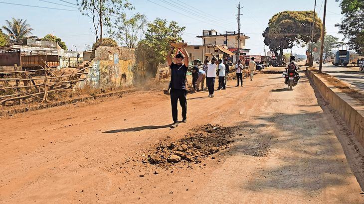 Villagers crossing huge potholes to reach the Mavli fair