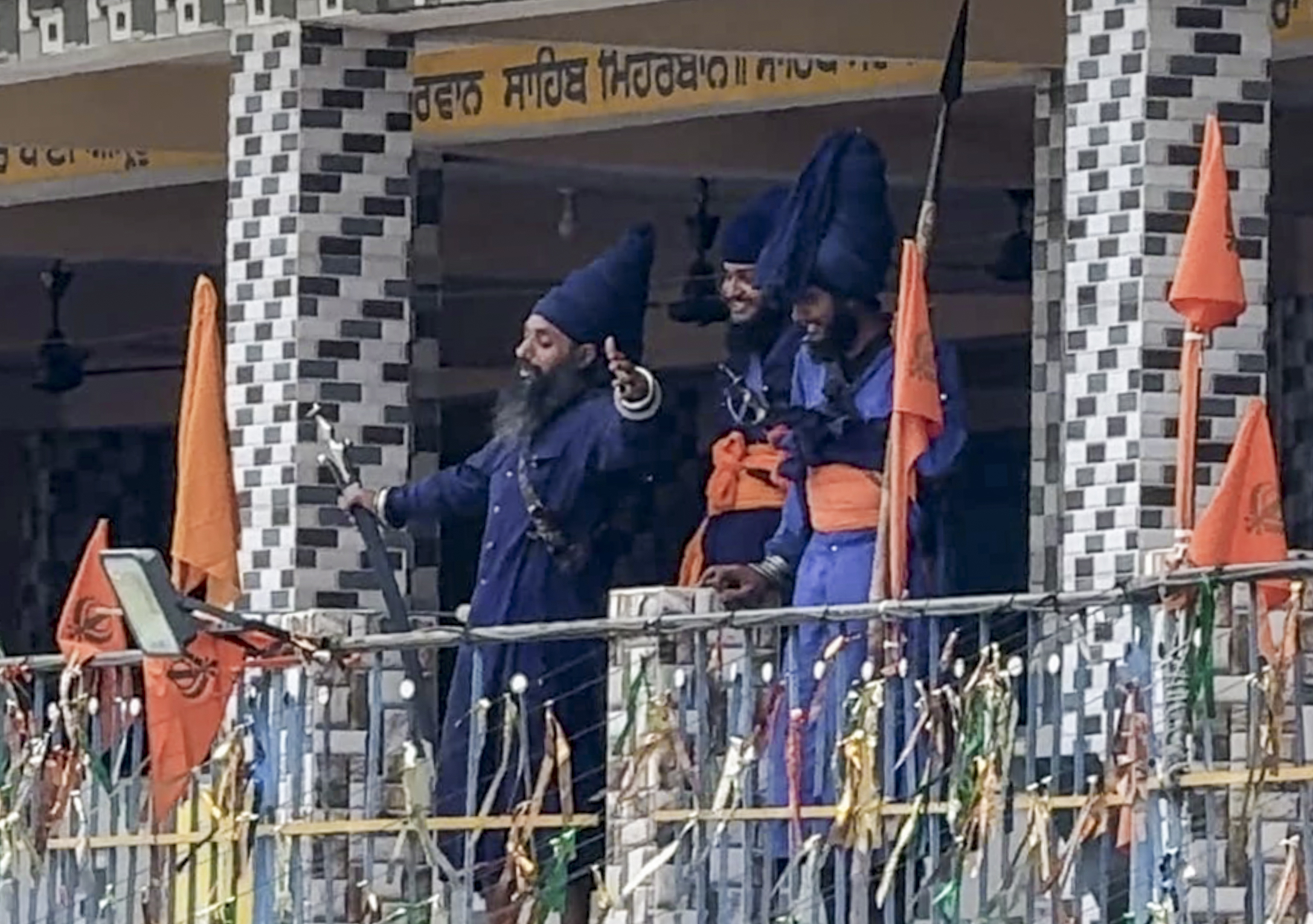 रुद्रप्रयाग: उत्तराखंड के रुद्रप्रयाग में ''निहंग'' चमोली जिले में झड़प के बाद गिरफ्तार किए गए सिख संप्रदाय के चार सदस्यों की रिहाई की मांग को लेकर गुरुद्वारे की छत पर खड़े हैं। (छवि स्रोत: पीटीआई फोटो)