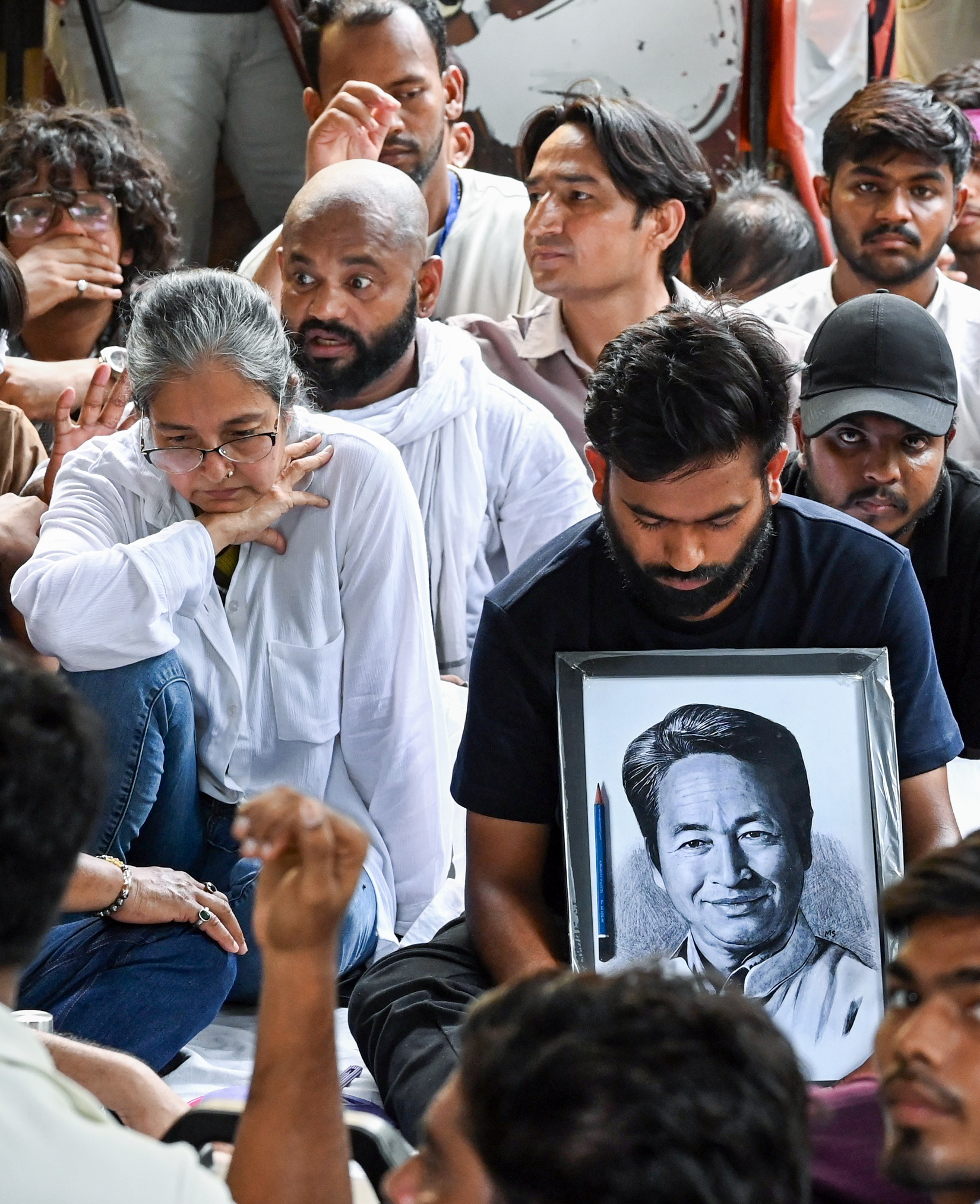 CJP founder Abhijeet Dipke holds a portrait of Sonam Wangchuk after launching his own indefinite hunger strike following Wangchuk's hospitalisation, at Jantar Mantar in New Delhi on 18 July.