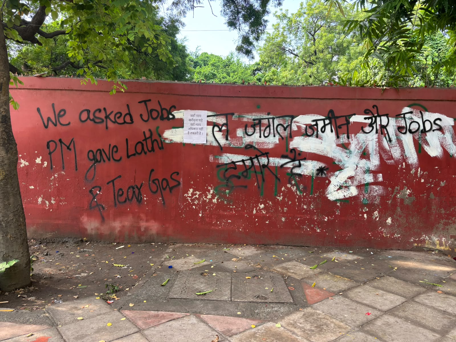 विरोध भित्तिचित्र नौकरियों की मांग को शिक्षा और शासन पर चिंताओं से जोड़ता है।