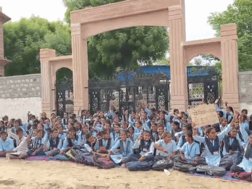 Students sitting in front of the school gate in Jalore, Rajasthan