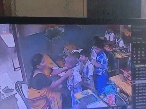 The teacher pulls the child close, slaps him, then scolds him.