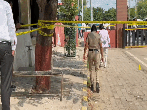 Police personnel searching for empty bullet shells after the gangster's murder
