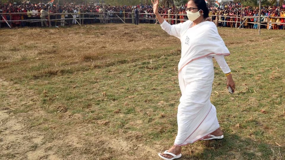 Clad in a white cotton saree and simple hawaiian chappals on her feet Mamata Banerjee waves at her supporters in Nandigram. (ANI)