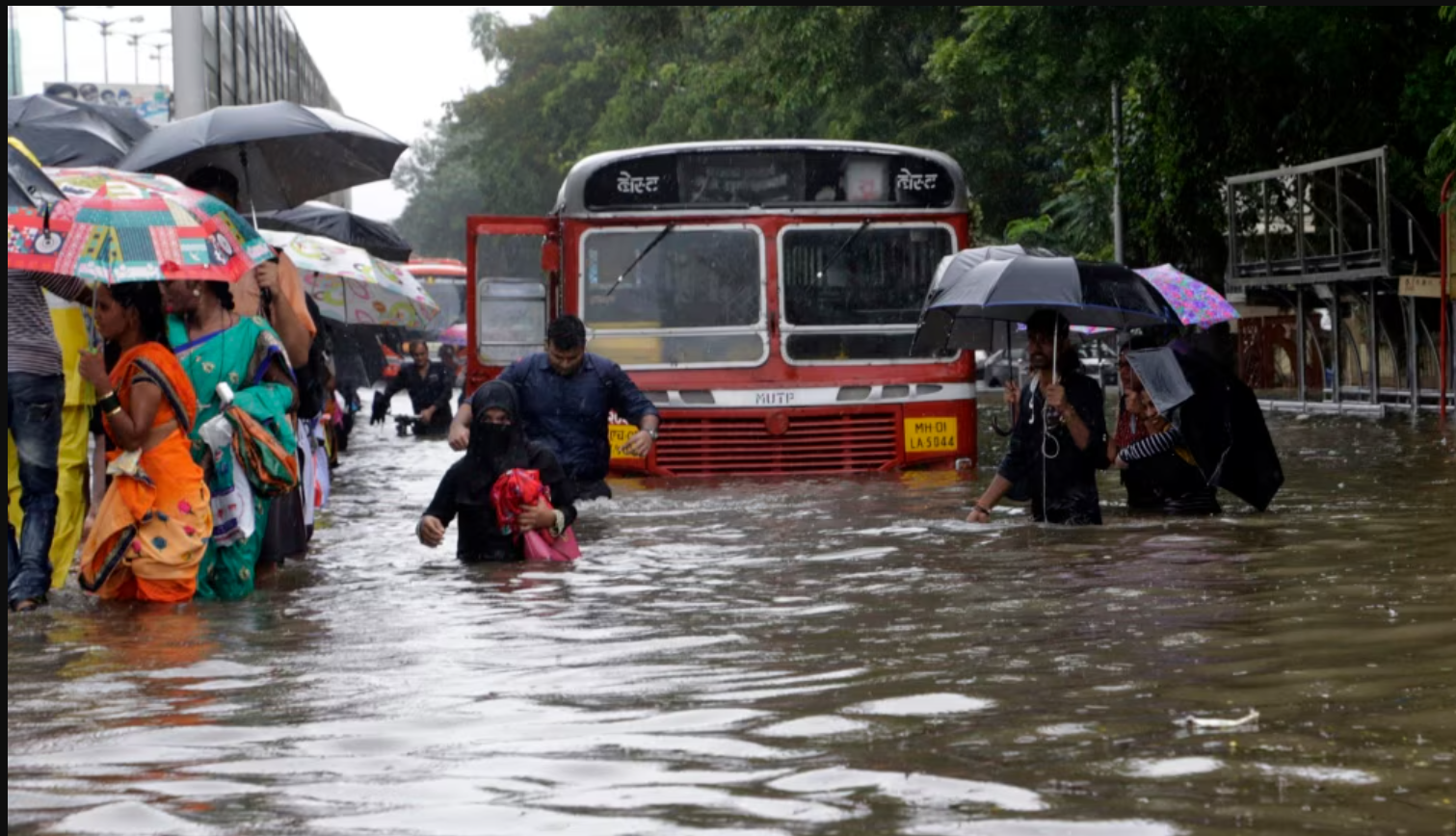 People walk through a waterlogged street following heavy rains in Mumbai, India (Representative Image)