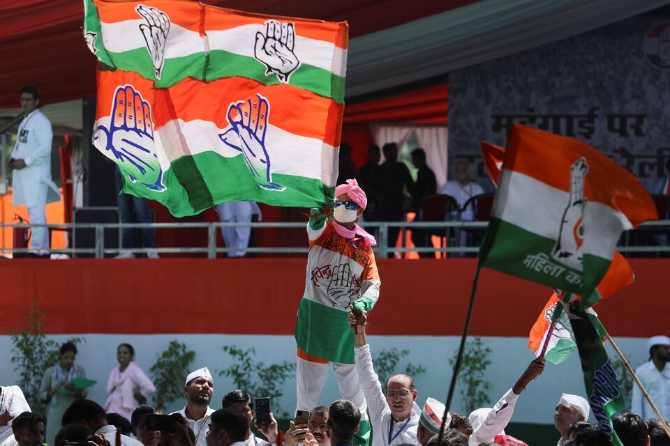A supporter waves a flag of Congress party at rally