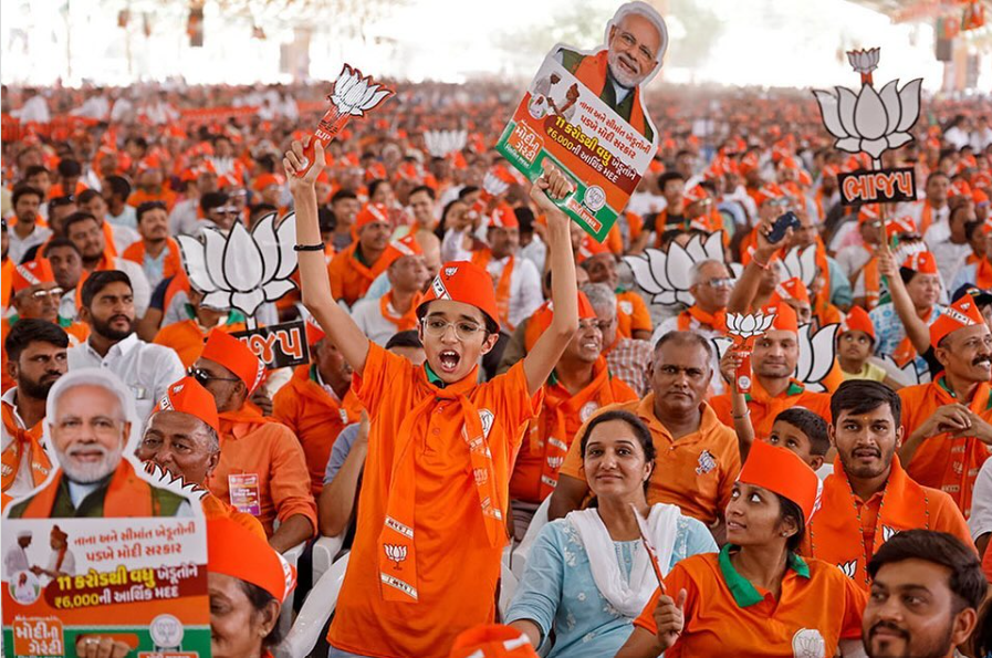 Supporters hold cut-outs of Lotus, the symbol of Bharatiya Janata Party (BJP) during an election campaign rally.