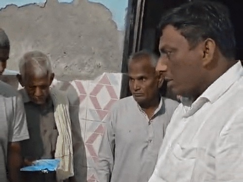 The councillor's representative and others checking the ration at the anganwadi centre.
