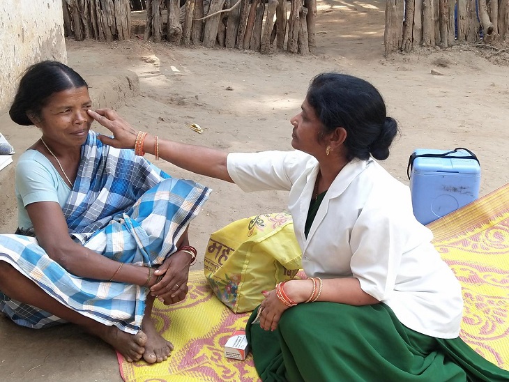 स्वास्थ्य कार्यकर्ता गंगा, ग्रामीण की जांच करते हुए। - Dainik Bhaskar