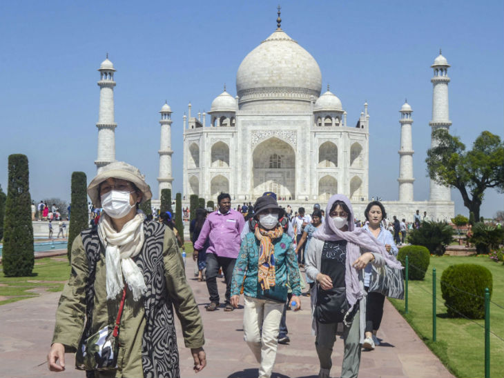 ताजमहल के पास पर्यटकों को मास्क लगाए देखा गया।