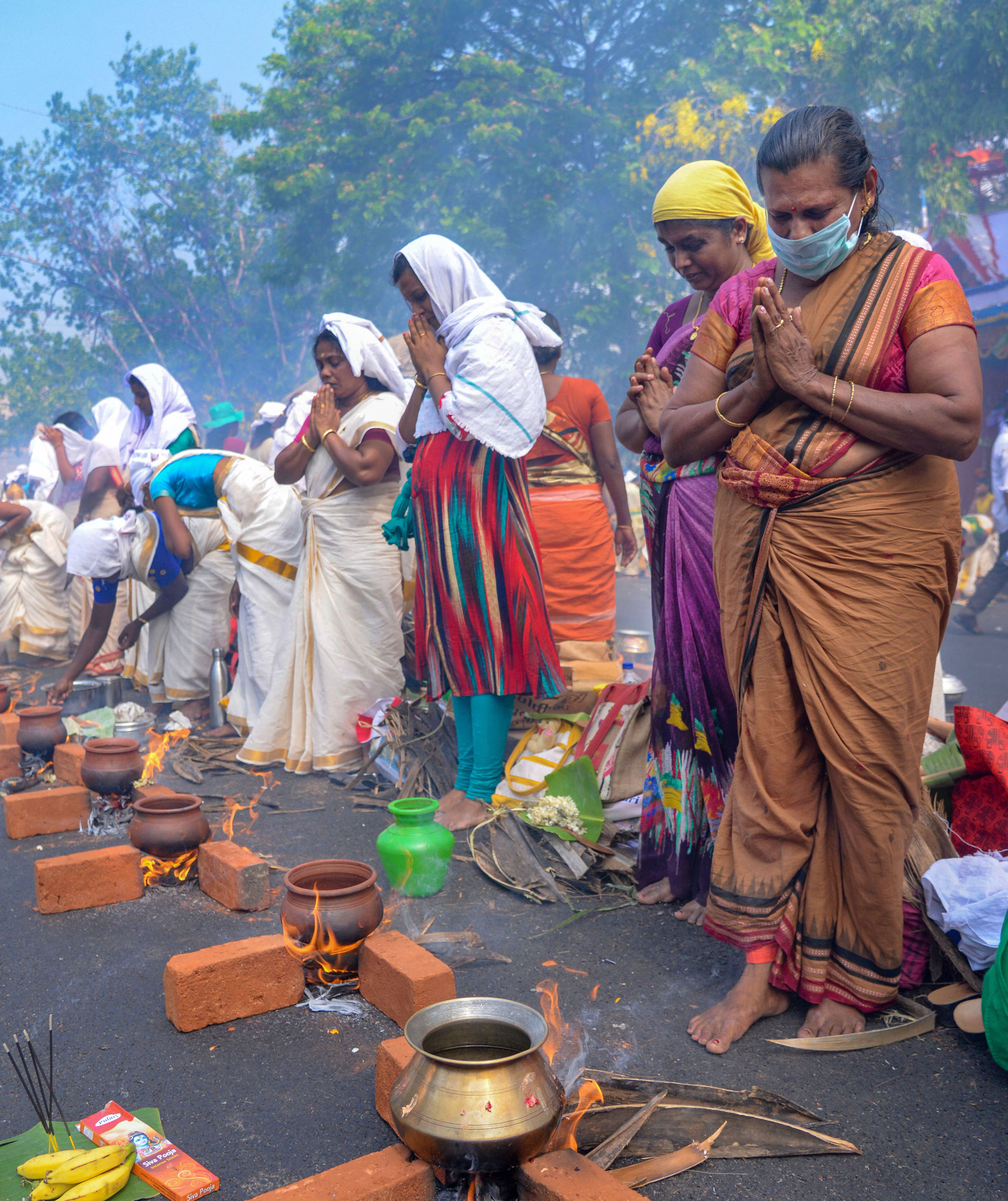 तिरुवनंतपुरम में मास्क लगाकर अट्‌टुक्कल पोंगल पर पूजा करती महिलाएं।