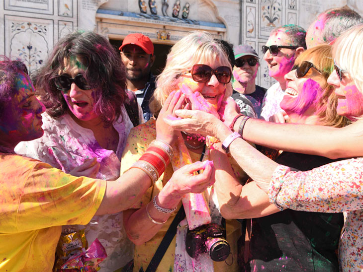 अमृतसर के मंदिर में विदेशी सैलानियों ने एक-दूसरे को गुलाल लगाया।