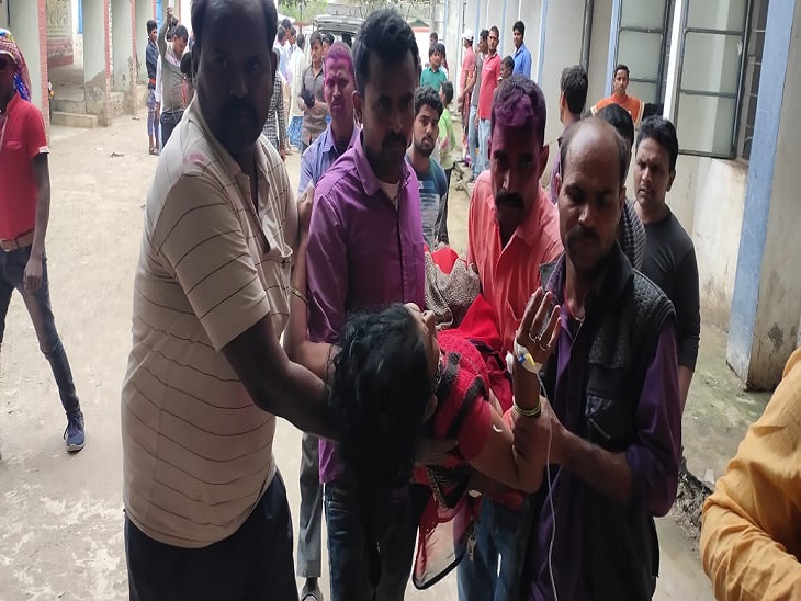 घायल महिला को अस्पताल ले जाते लोग। - Dainik Bhaskar