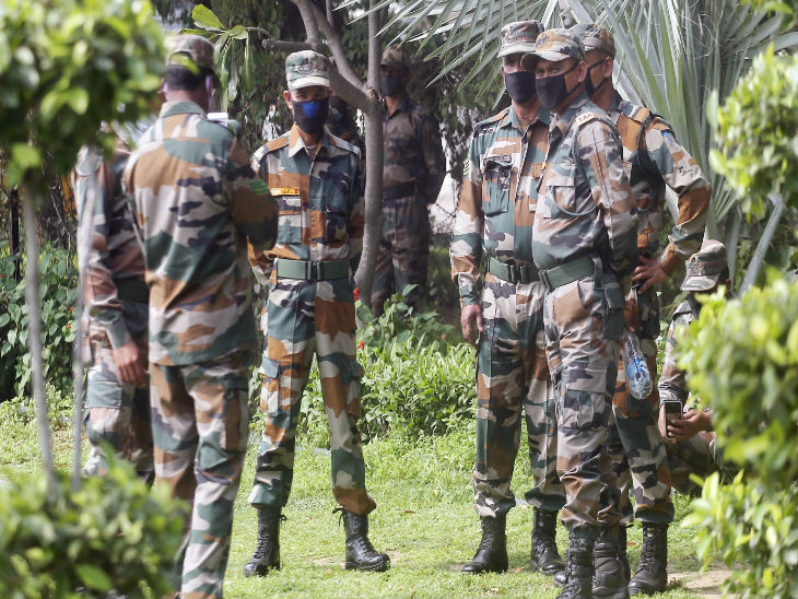 दिल्ली में चीनी दूतावास के पास मास्क पहनकर तैनात पैरामिलिट्री फोर्स के जवान।