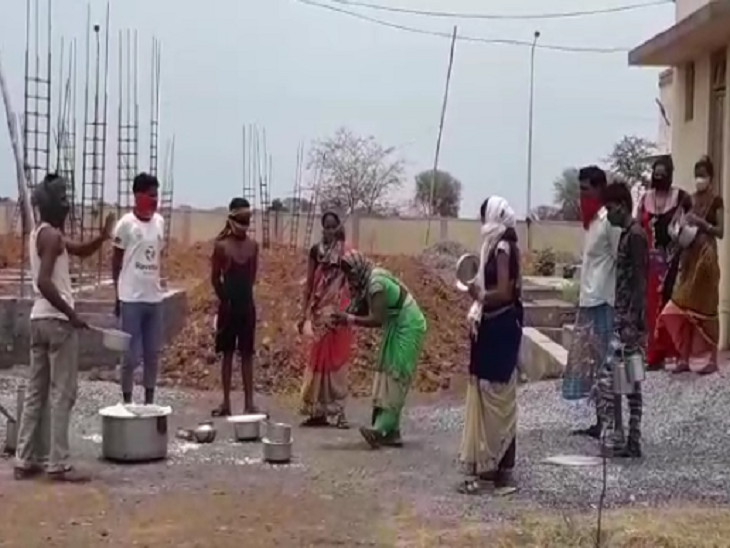 श्रमिकों को खाना इसी तरह दूर से फेंककर दिया जा रहा है, भोजन जमीन पर गिर रहा है, हाथ में बर्तन लिए लोग इंतजार कर रहे हैं, फोटो - राकेश जायसवाल