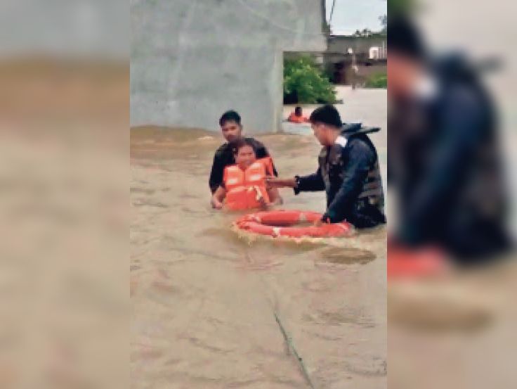 गर्भवती महिला को सुरक्षित निकाल कर लाते बचाव दल के सदस्य।
