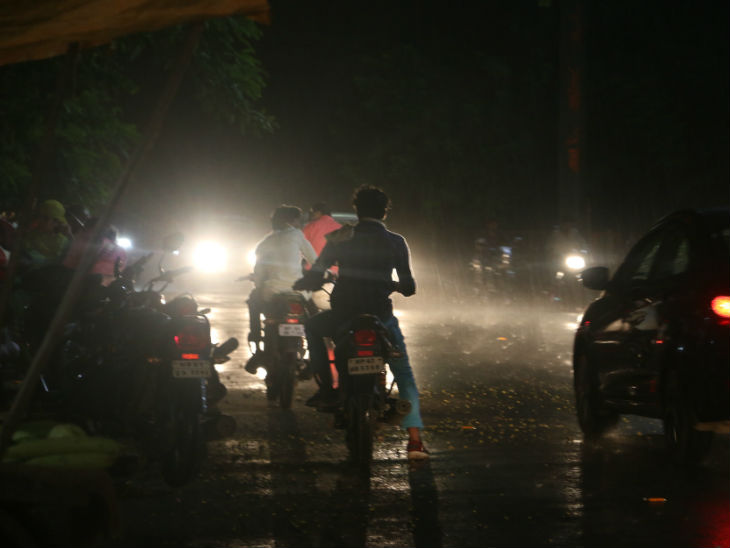 भोपाल में कैंपियन स्कूल के पास लोग बारिश से बचने के लिए पेड़ों के नीचे खड़े हो गए।
