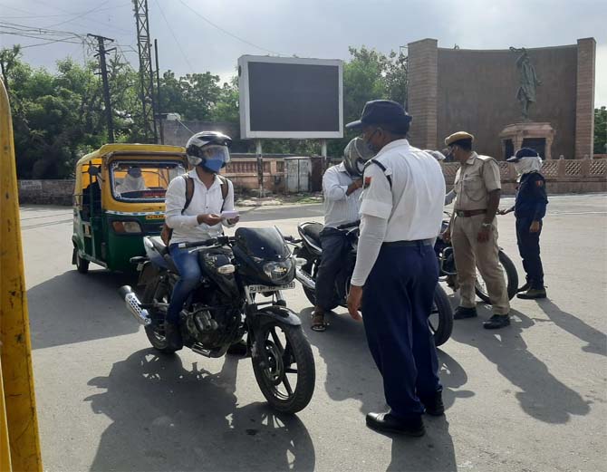 लॉक डाउन के दौरान बाहर निकले लोगों से पूछताछ करती पुलिस।