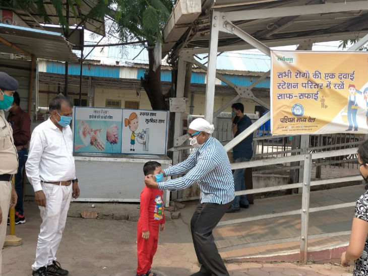 भोपाल रेलवे स्टेशन पर यात्रियों को रेलवे द्वारा मास्क दिए जा रहे हैं।