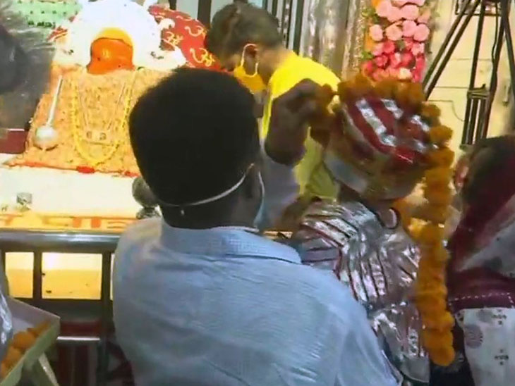 अपने बच्चे को लंगूर बनाकर हनुमान जी को माथा टेकने लंगूर मेले में आया एक दंपति।