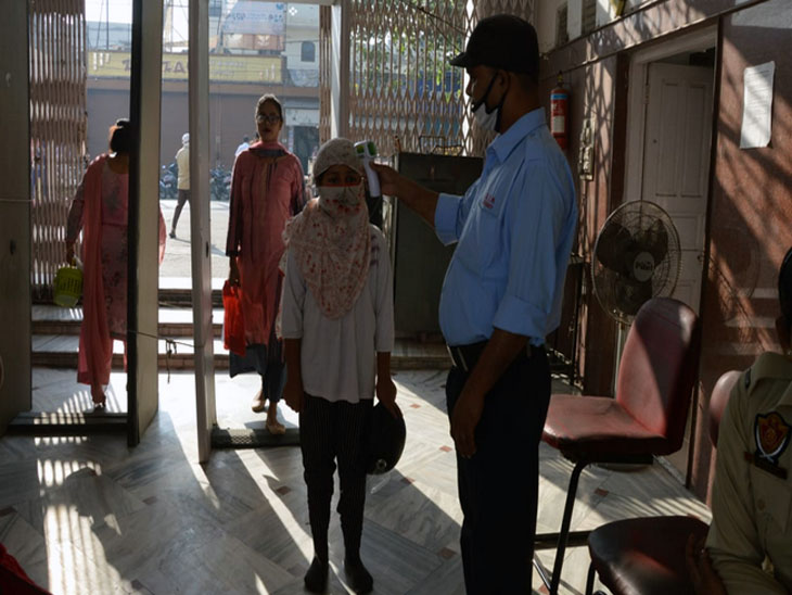 जालंधर के एक प्रमुख दुर्गा माता मंदिर में पूजा के लिए आए श्रद्धालुओं की थर्मल स्क्रीनिंग करता मंदिर प्रबंधन कमेटी तरफ से तैनात सुरक्षाकर्मी।