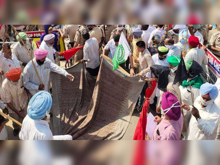 आगे नहीं बढ़़ने देने के बाद चौक पर ही देर बिछाकर धरने की तैयारी करते नाराज किसान।