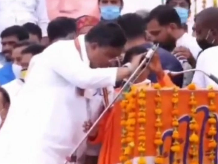 माइक पकड़कर राम सिया को भाषण के दौरान क्या कहना है इसके बारे में बताते हुए।