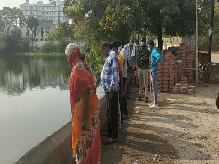 गोपाल बाग तलैया में उतरा रहे शव को देखते हुए लोग