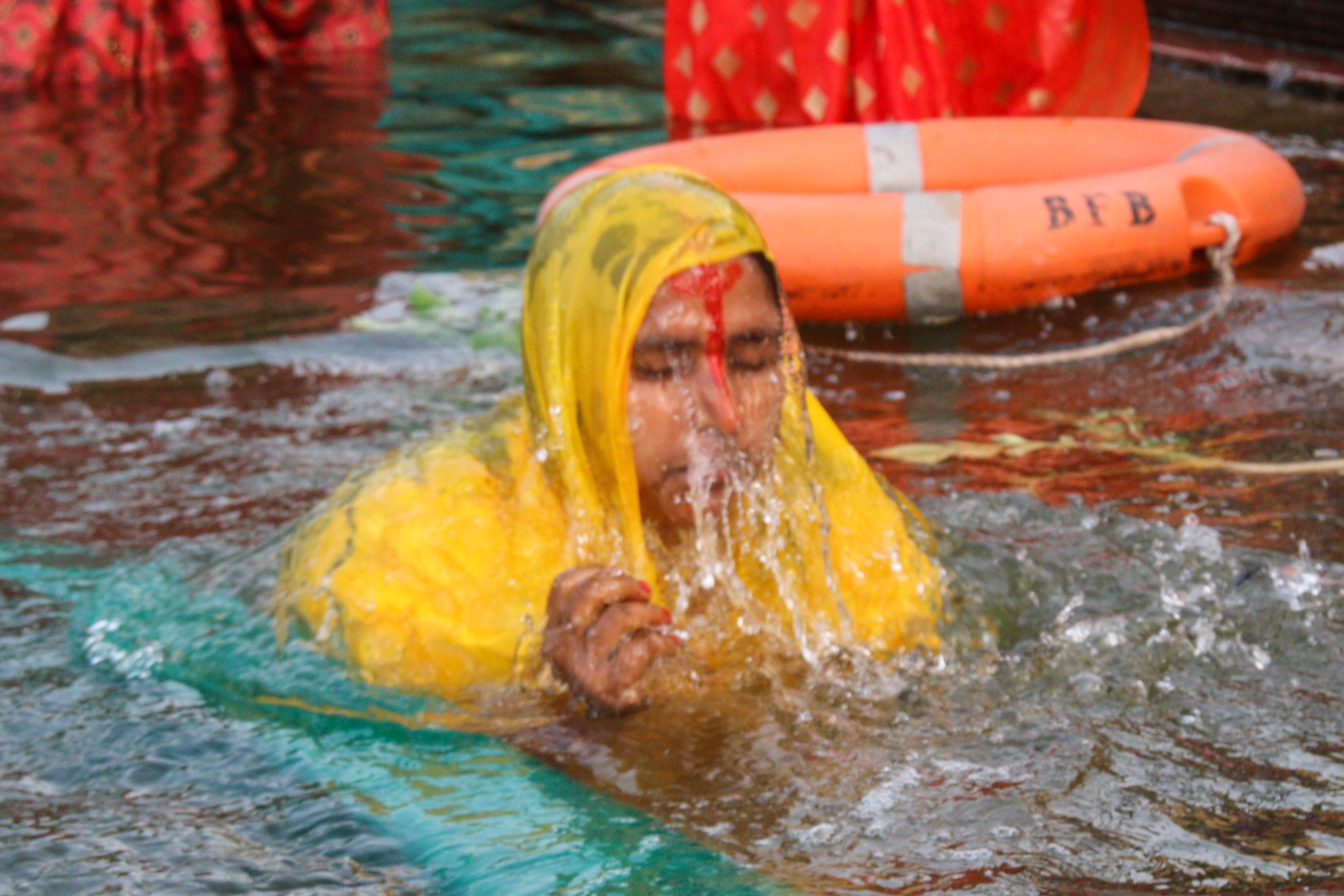 शीतलदास की बगिया में पूजा के दौरान डुबकी लगाती महिला।