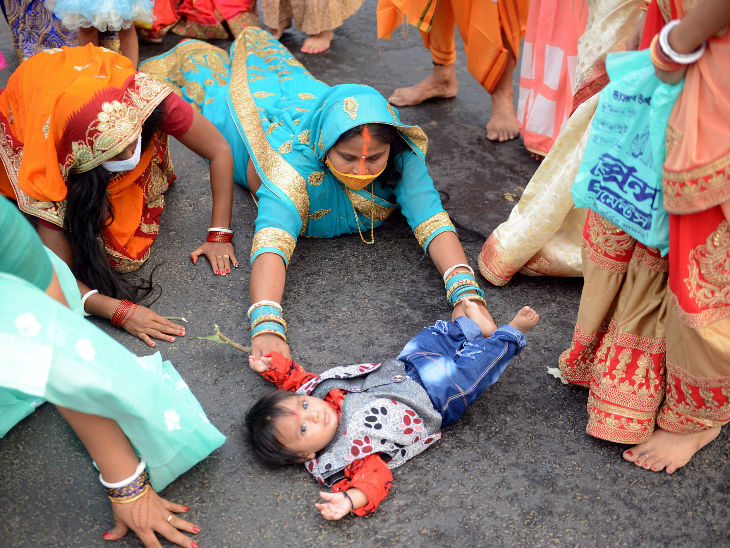 कोलकाता के दोही घाट पर बच्चे के साथ पूजा करने पहुंची महिला।