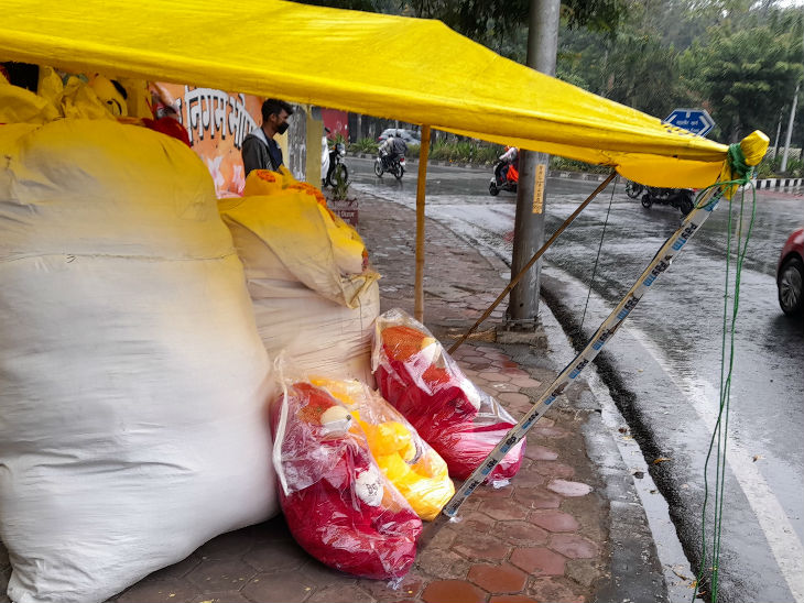 बारिश के कारण फुटपाथ पर दुकानदारों को अपना सामान पंडाल के अंदर रखना पड़ा।