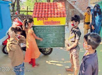 सागर | चलित स्कूल के बोर्ड में पढ़ते बच्चे।