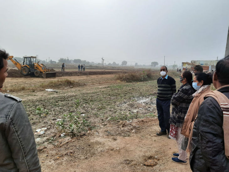 जमीन मुक्त कराने के दौरान बातचीत करते एसडीएम व अन्य अधिकारीगण