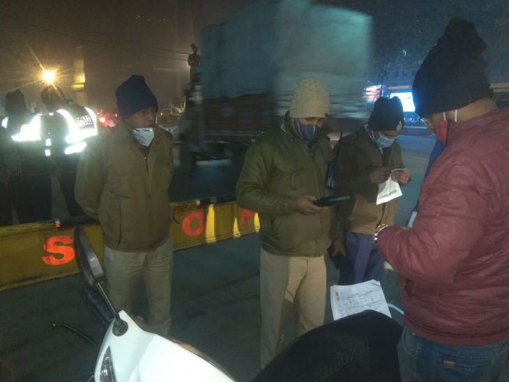 सड़क पर वाहन चालकों को रोककर दस्तावेज चेक करती पुलिस।
