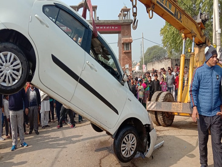 क्रेन द्वारा नहर से उद्यमी की कार निकालते हुए।