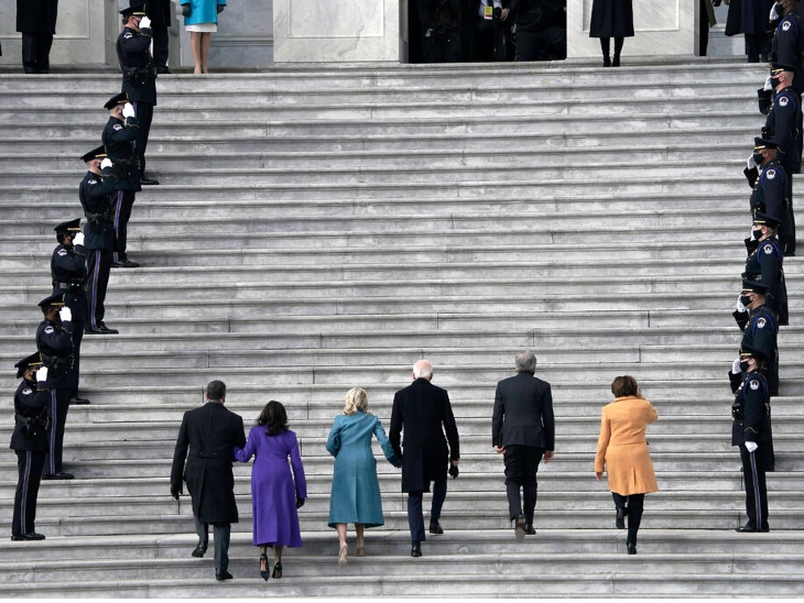 पत्नी जिल का हाथ थामे बाइडेन सीढ़ियां चढ़ते हुए। बाईं तरफ पर्पल कलर की ड्रेस में कमला हैरिस पति डग एमहॉफ का हाथ थामे नजर आ रही हैं।