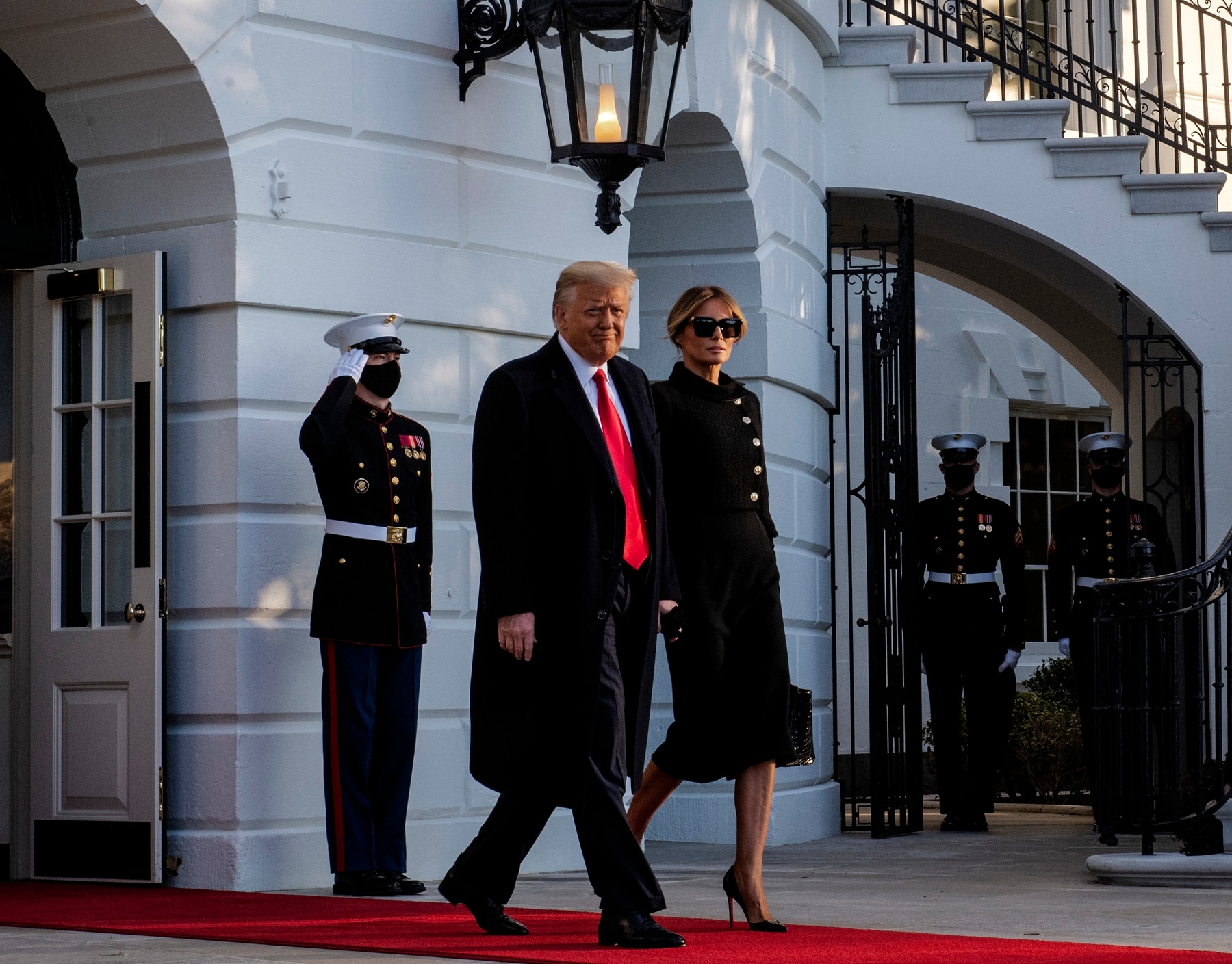राष्ट्रपति डोनाल्ड ट्रम्प और फर्स्ट लेडी मेलानिया व्हाइट हाउस से जाते हुए।