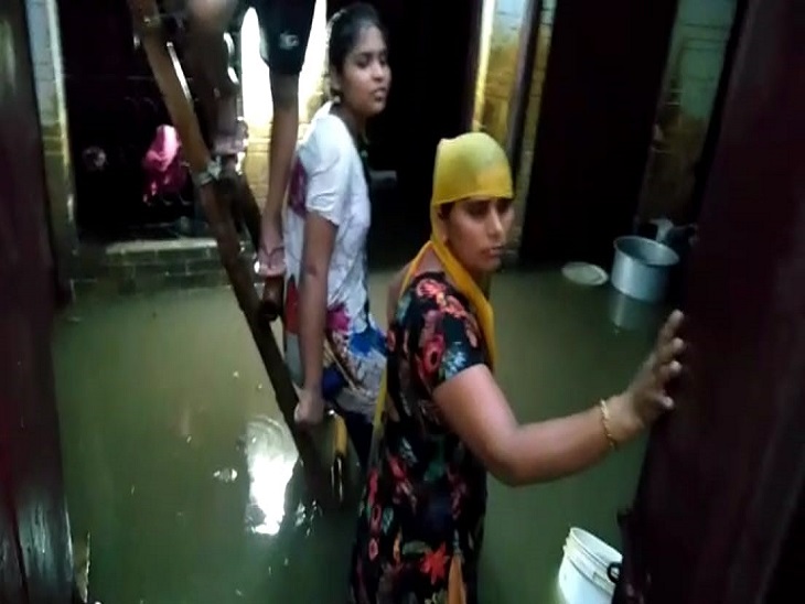 तिगांव में एक घर में घुसा पानी, तैरता सामान, अंदर खड़े घर के लोग