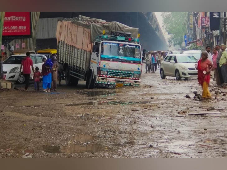बारिश के पानी से गुजरते वाहन और पैदल आ-जा रहे लोग।