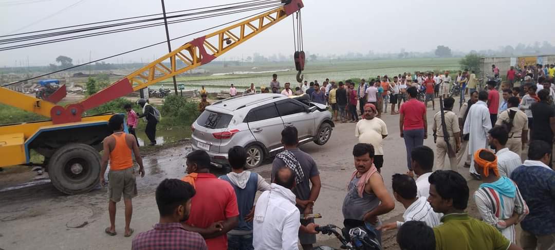 क्रेन से कार को निकालने के दौरान लोगों की जुटी भीड़।