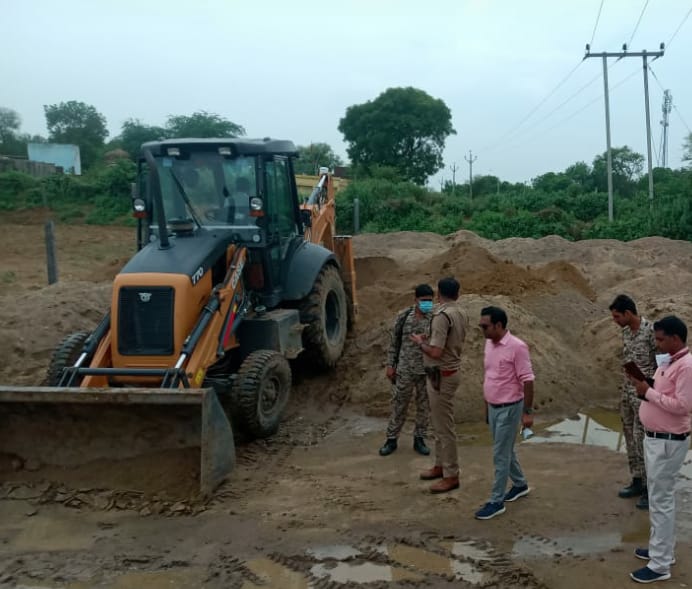 डंप रेत को मिट्टी में मिलाती जेसीबी
