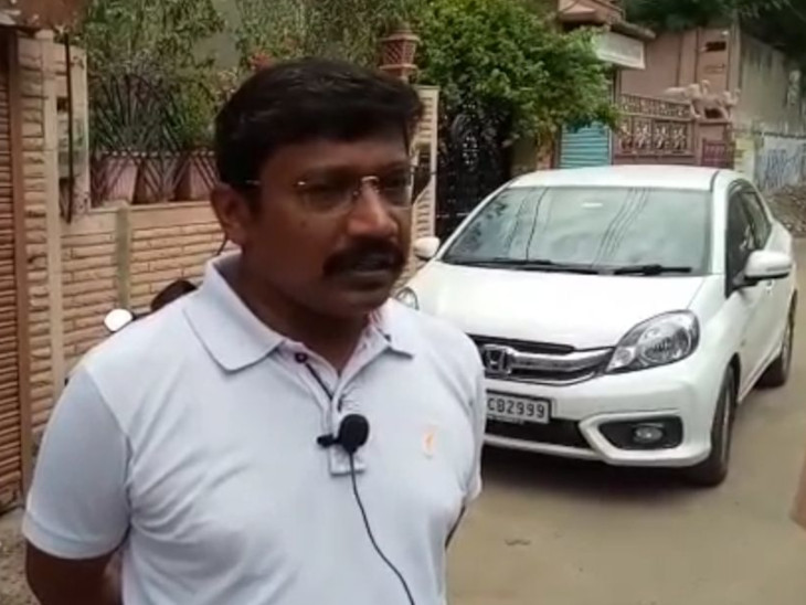 व्यापारी अमित पंसारी और पीछे खड़ी कार
