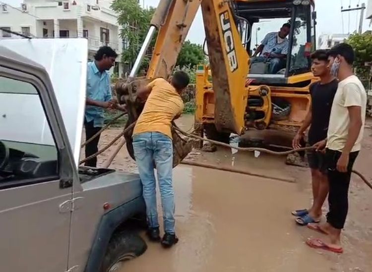 जेसीबी की सहायता से जीप को खडडे से बाहर निकालते हुए।
