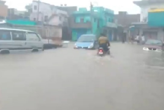 झालावाड़ में तेज बारिश के बीच गुजरते वाहन।