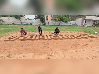 स्काउट गाइड कार्यालय में मिट्टी को तराश कर दैनिक भास्कर का मास्ट हेड तैयार करते स्काउट गाइड।