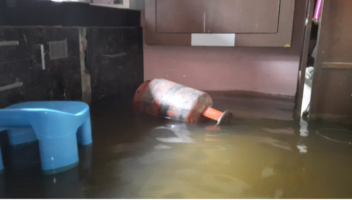 रसोई में किचन का सामान, सिलेंडर पानी में तैर रहे हैं।