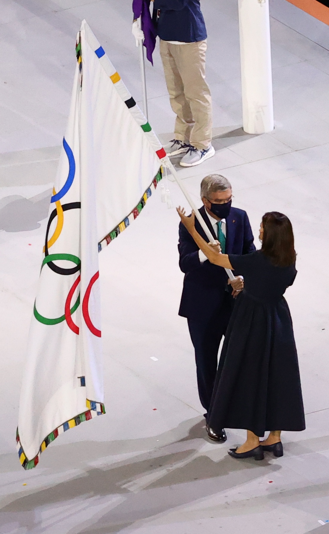 IOC के अध्यक्ष थॉमस बाक पेरिस की मेयर को ओलिंपिक ध्वज सौंपते हुए।